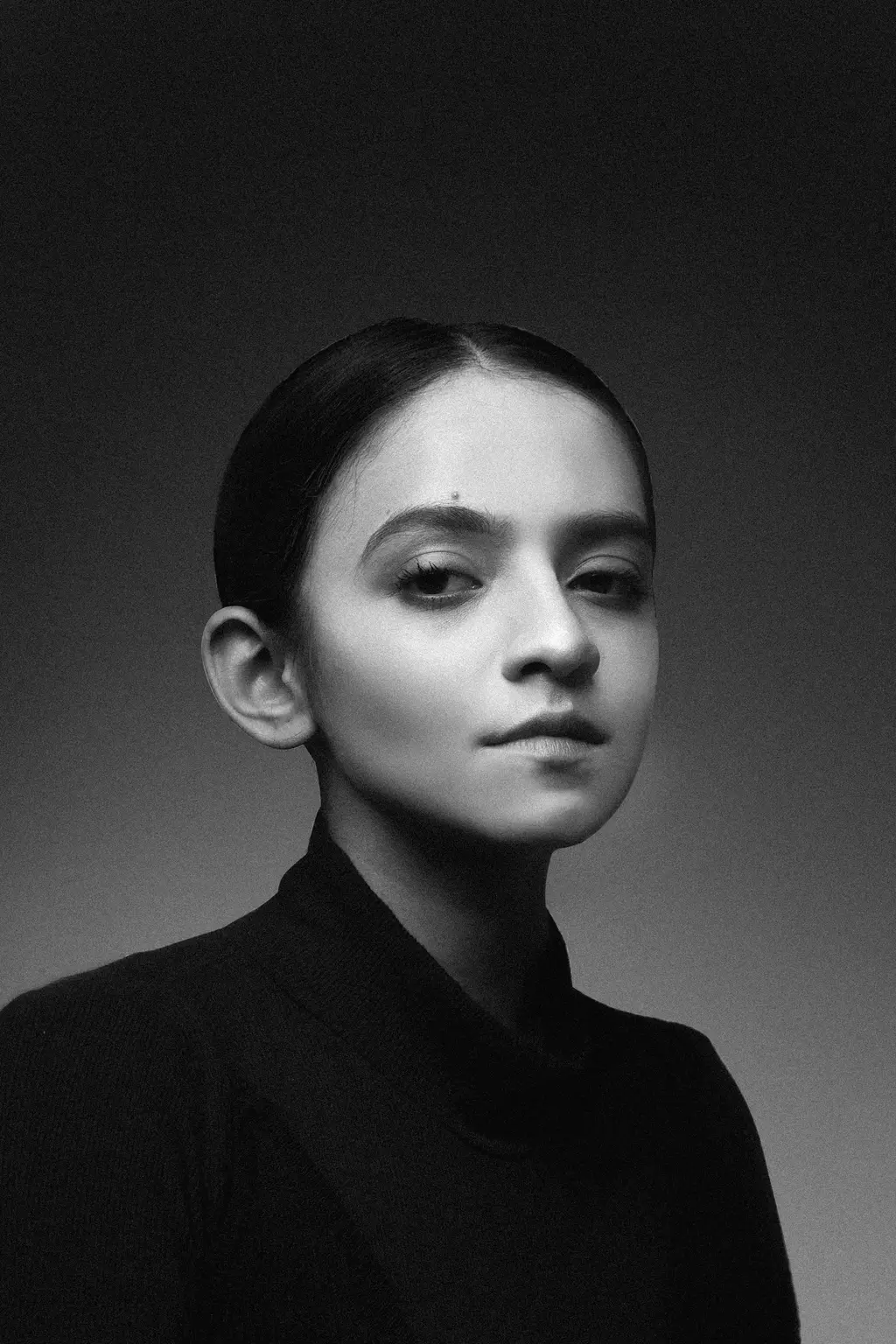 Série Comparses : portrait en noir et blanc d'une jeune femme aux cheveux tirés