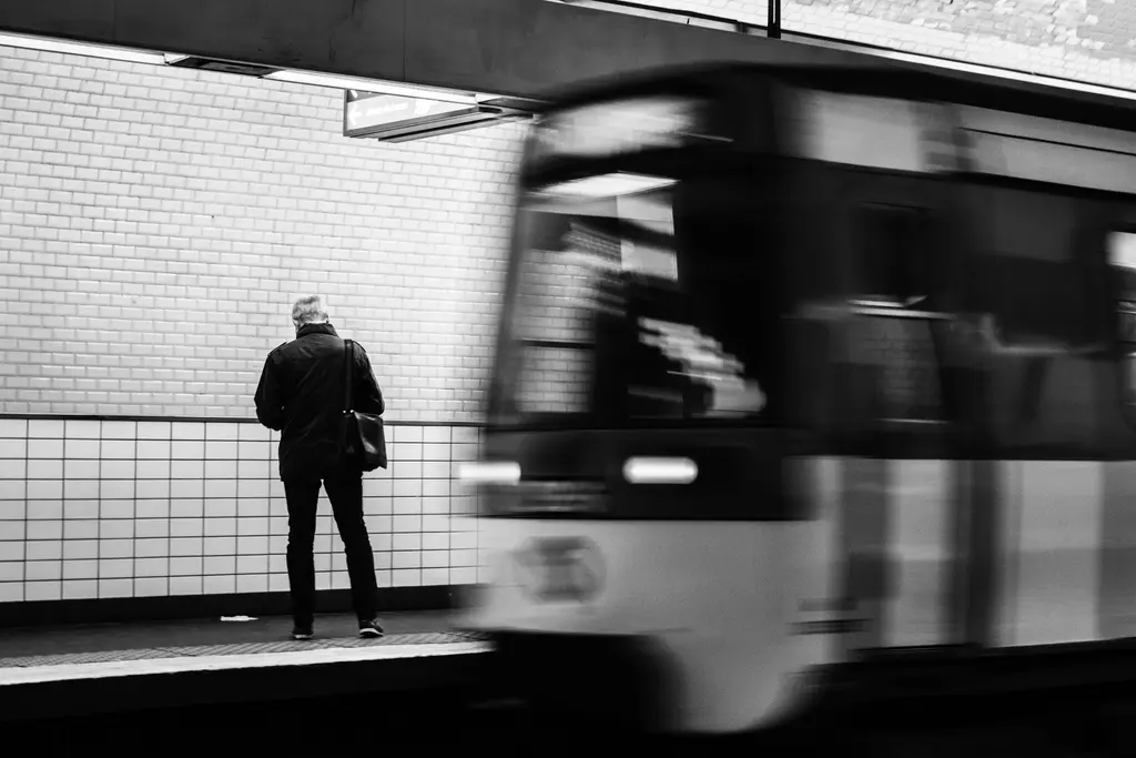 Série Marolles, hiver : un homme attend sur un quai pendant qu'une rame passe, floue