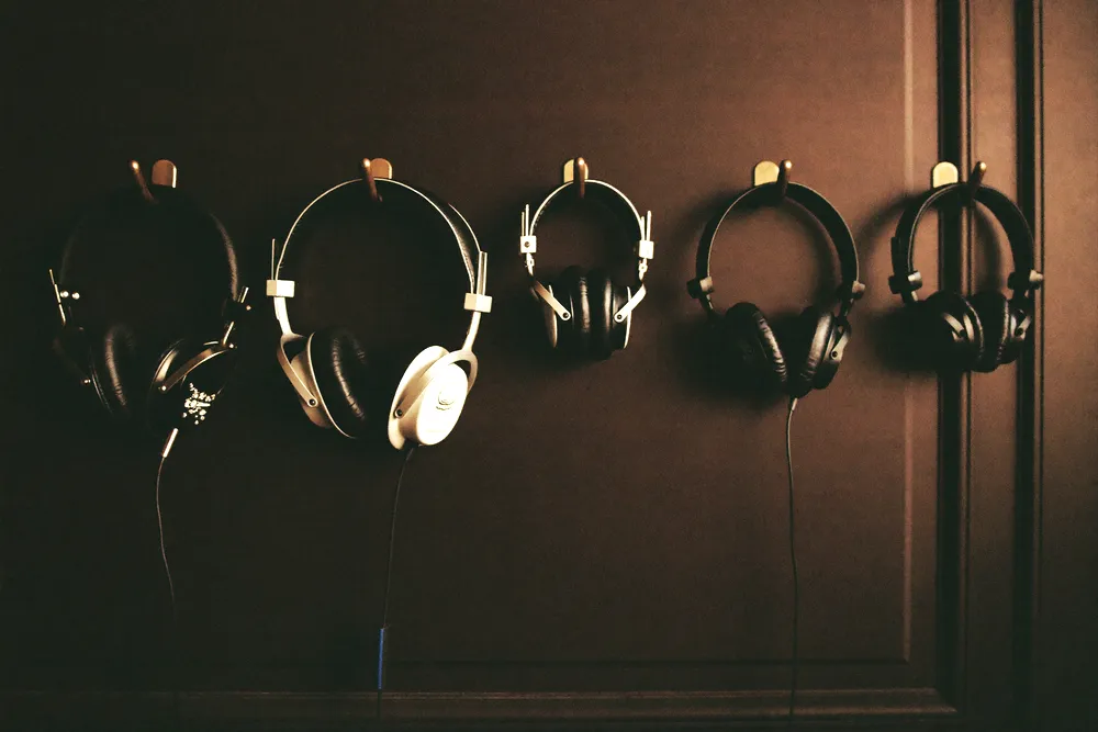 Casques audio suspendus à un mur sombre, un par invité